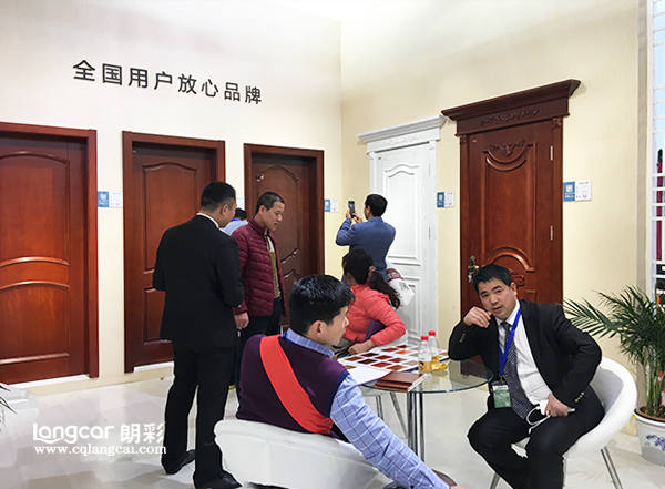 重(zhong)慶(qing)朗(lang)綵木(mu)門(men)：2017北(bei)京(jing)木(mu)門展現(xian)場(chang)銷(xiao)售人員(yuan)與客戶(hu)洽(qia)談